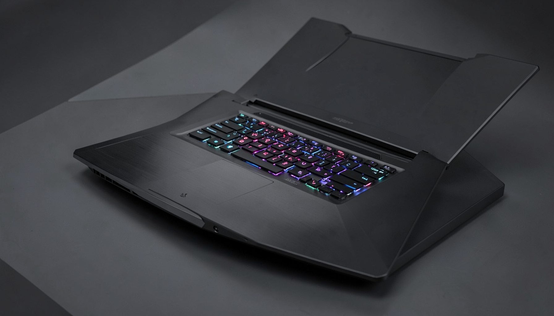 Gaming laptop with aggressive angular design and backlit keyboard, dark metallic finish